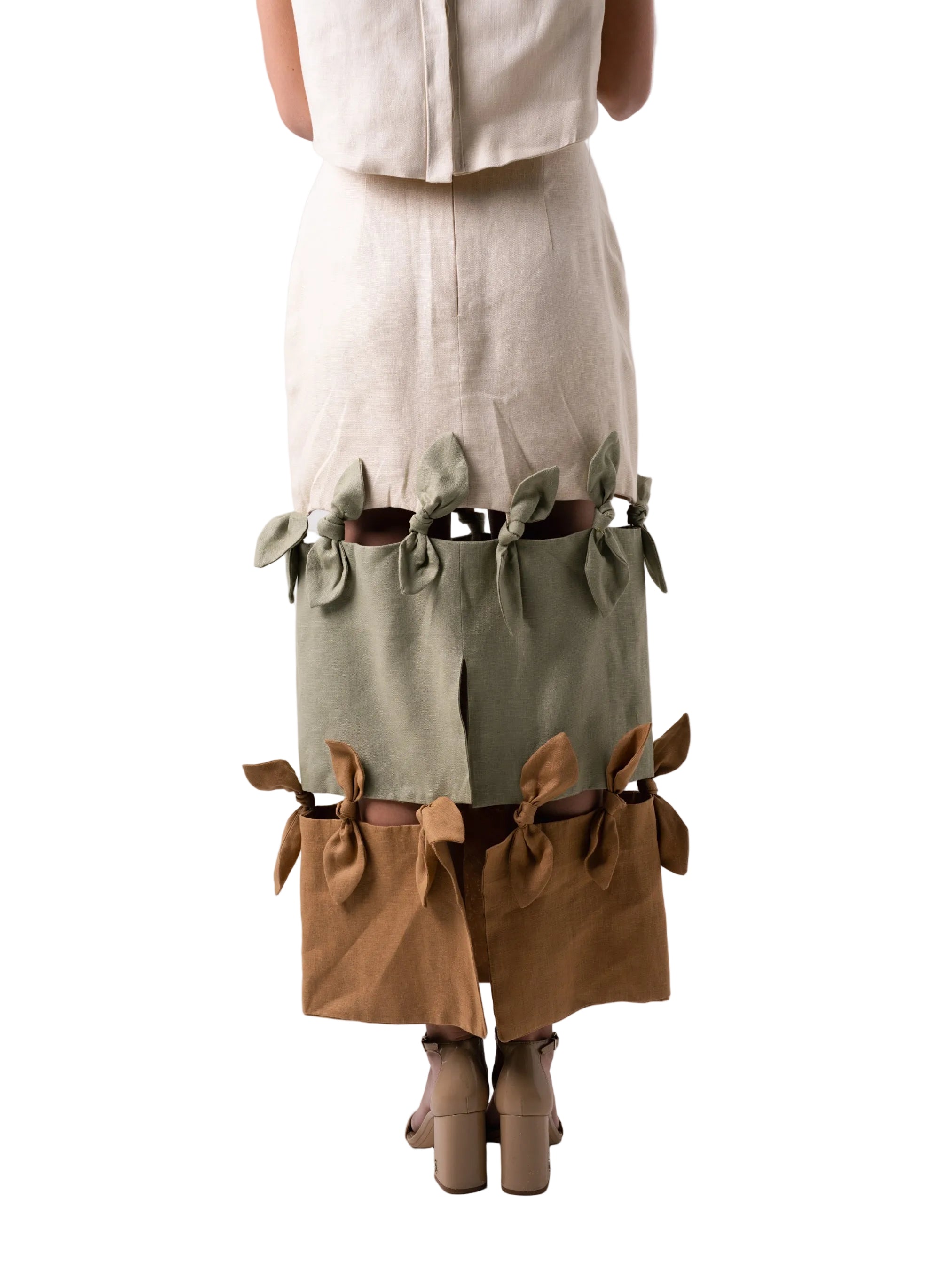 Pencil skirt silhouette with back slit, three-tier panel skirt with knotting details between panels.