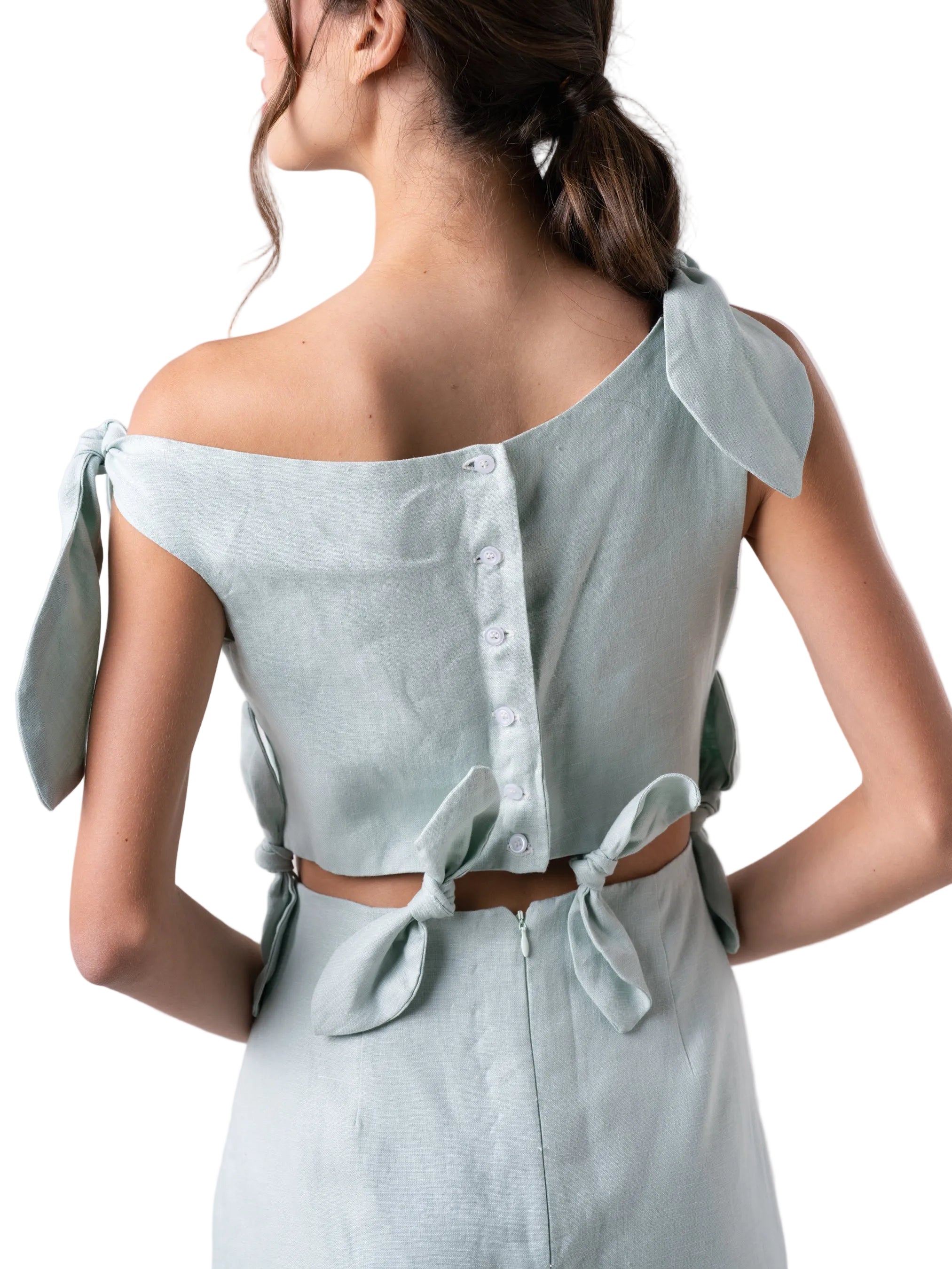 Dress features an ankle length straight silhouette, single dropped shoulder with cut out details and petal knots down the body.