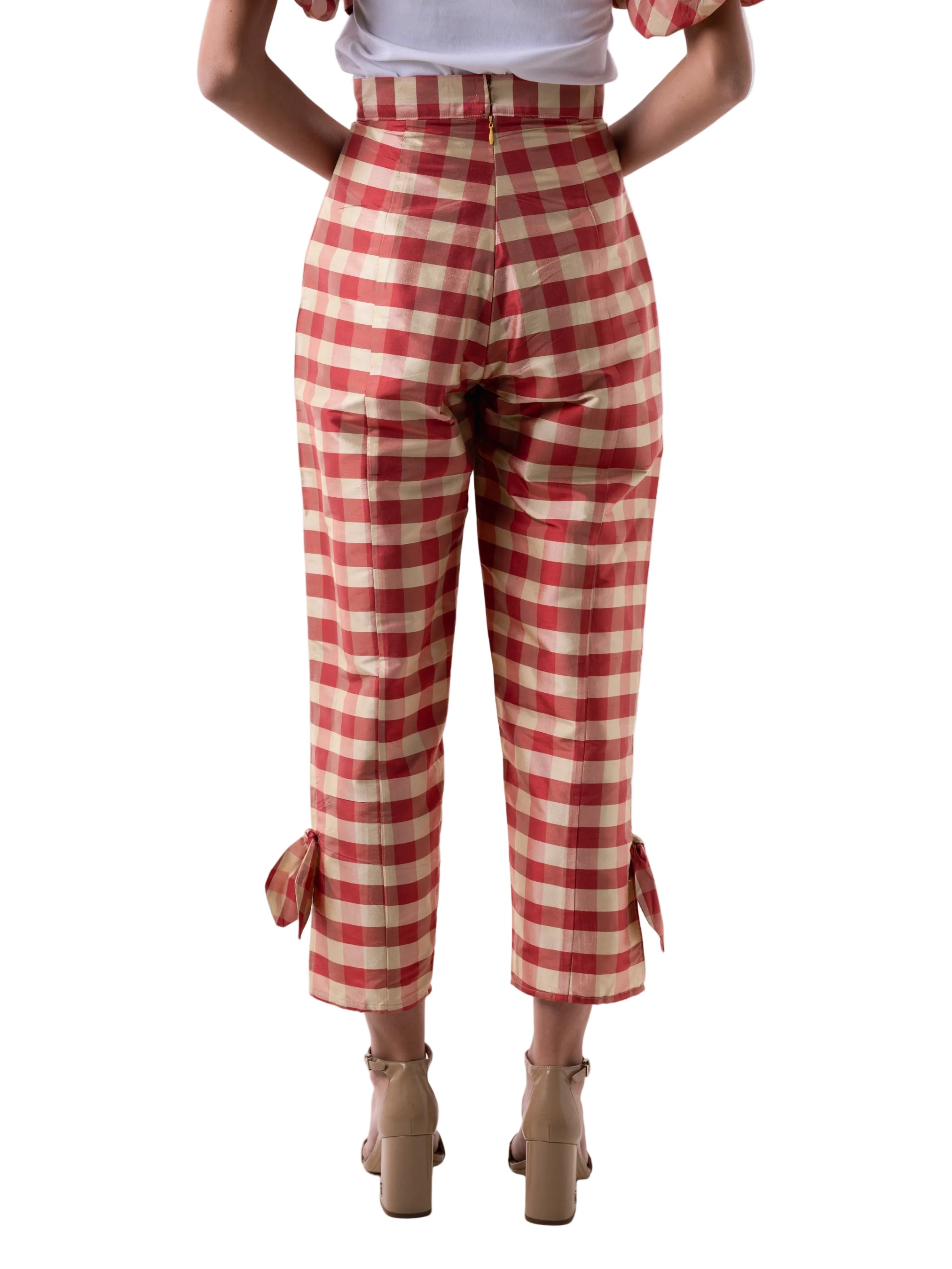 Pants that feature a high waist straight leg silhouette with slit detail at the ankle with knot detail, and back zipper closure.