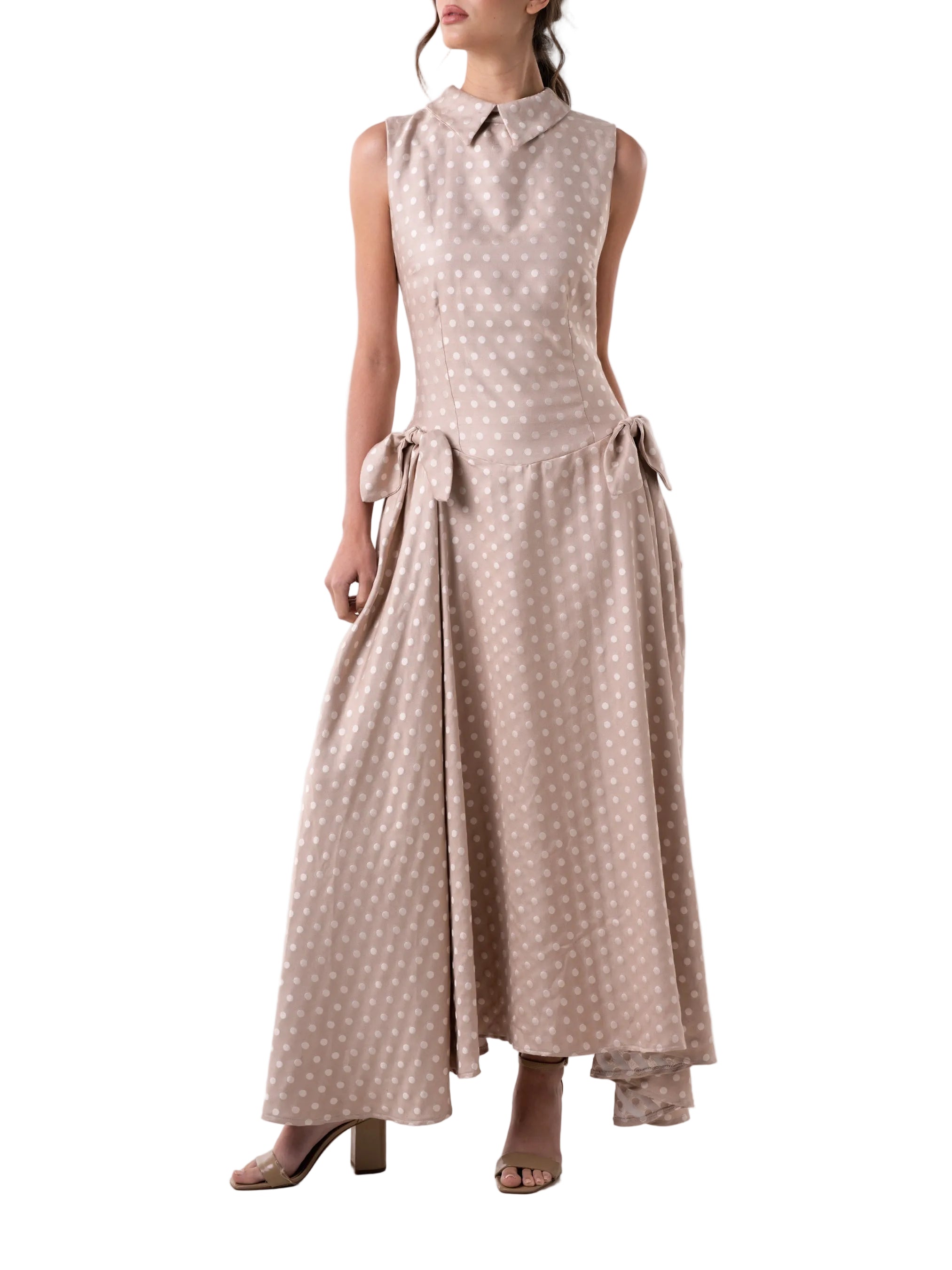 Dress that features a fit and flare dropped waist and ankle length silhouette, classic collar, petal knot detail and back zipper closure.