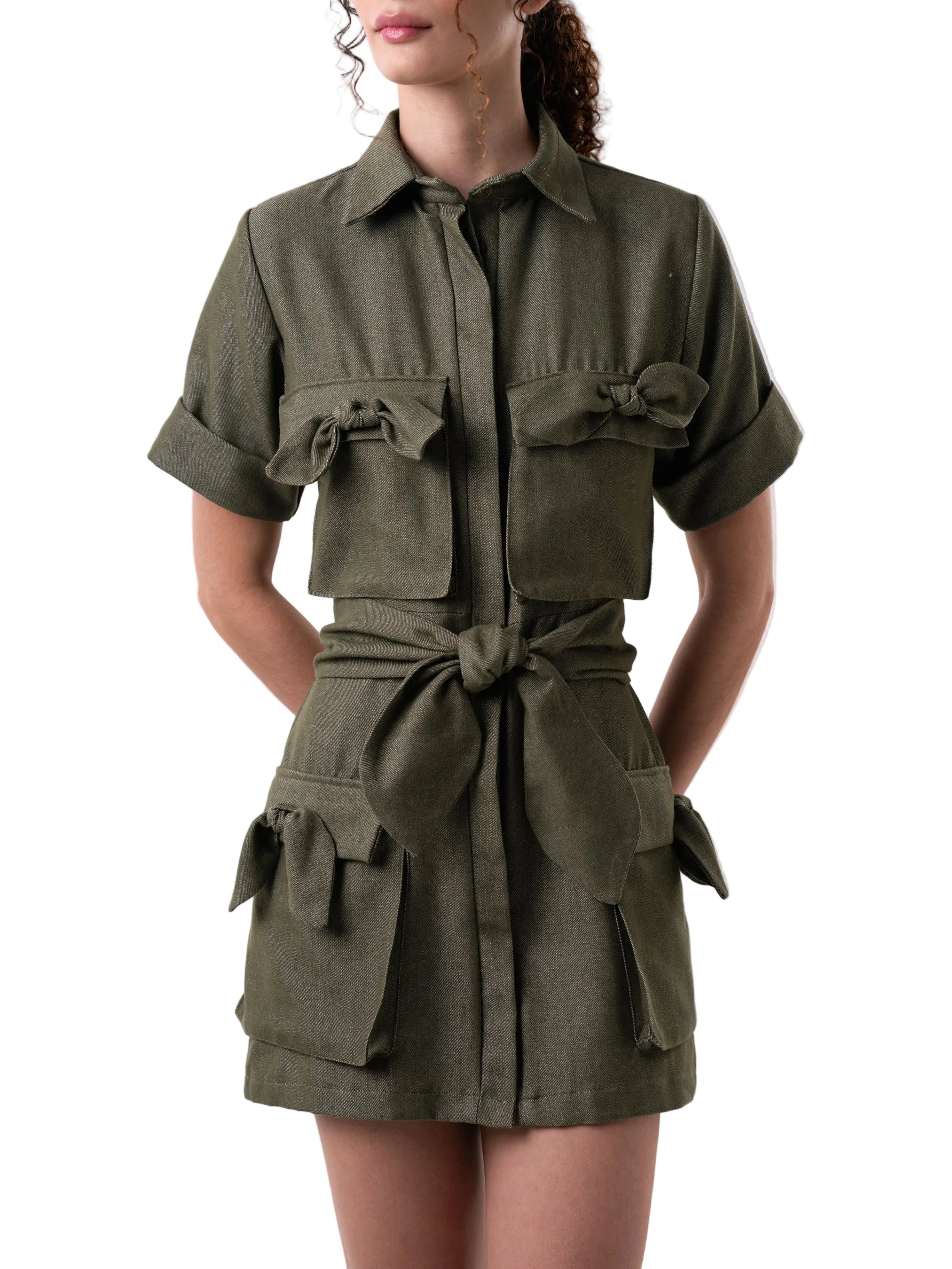 Dress features a short above the knee relaxed silhouette, short sleeves, body is adorned with oversized pockets with knot detail, button down closure and a matching belt for styling.