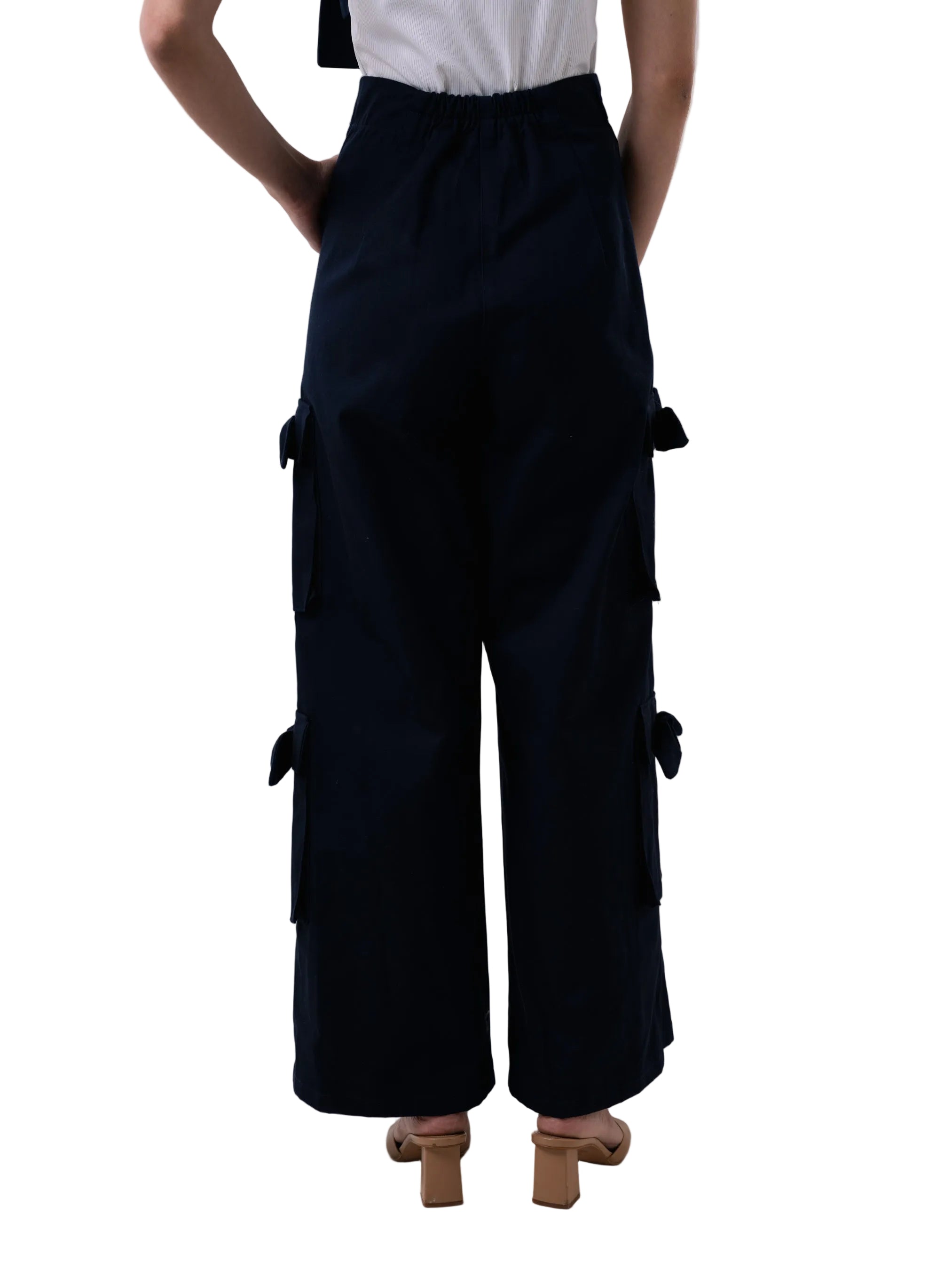 Pant with a high waisted cargo style, front zipper, and oversized pockets down the leg with knot details. Comes with matching strap for styling at the ankle.