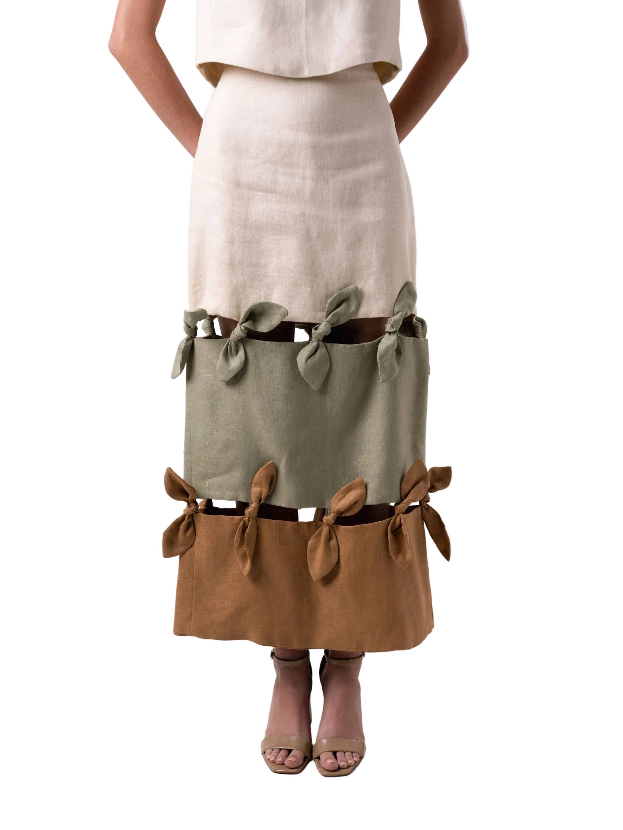 Pencil skirt silhouette with back slit, three-tier panel skirt with knotting details between panels.