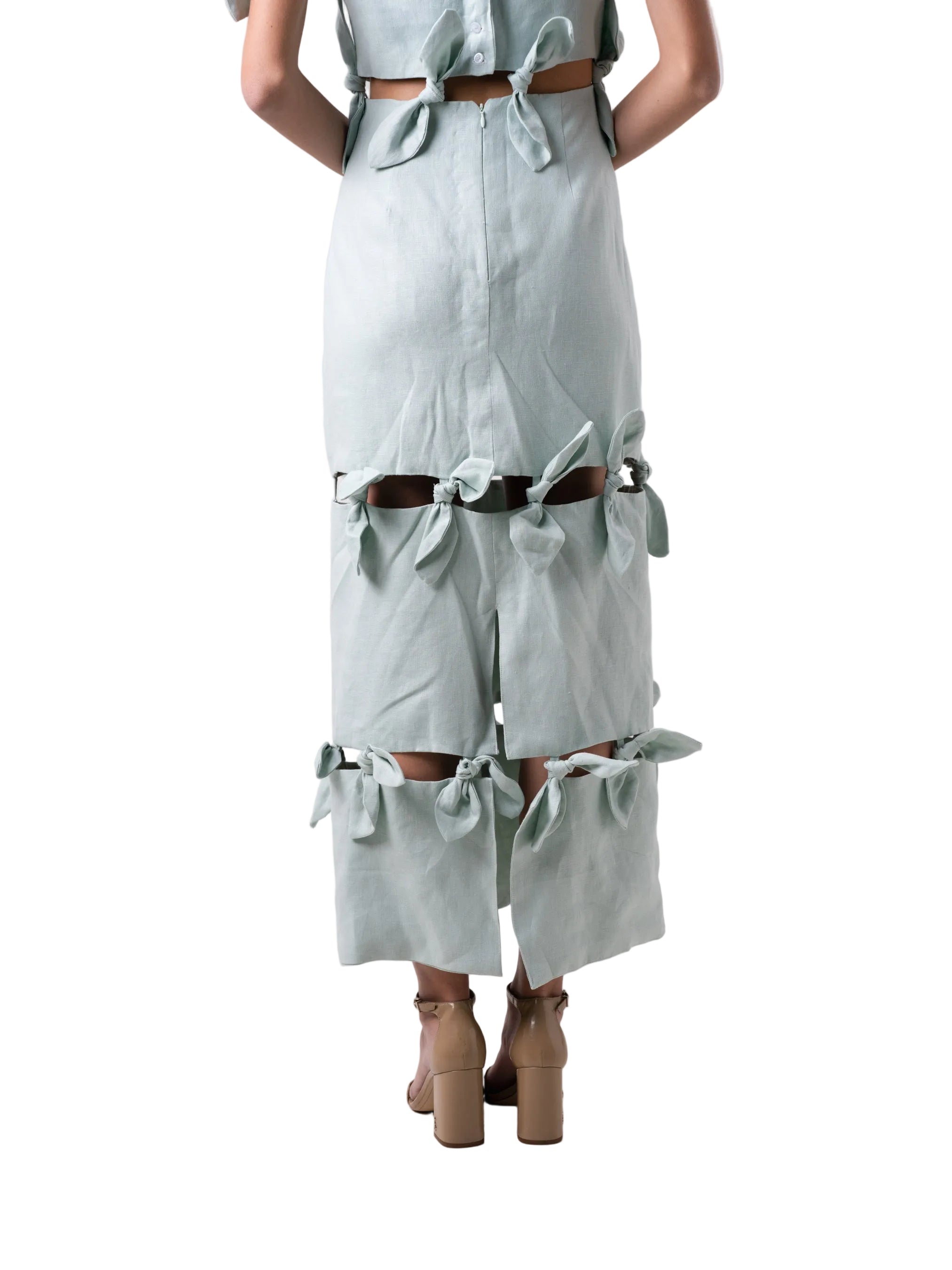 Dress features an ankle length straight silhouette, single dropped shoulder with cut out details and petal knots down the body.