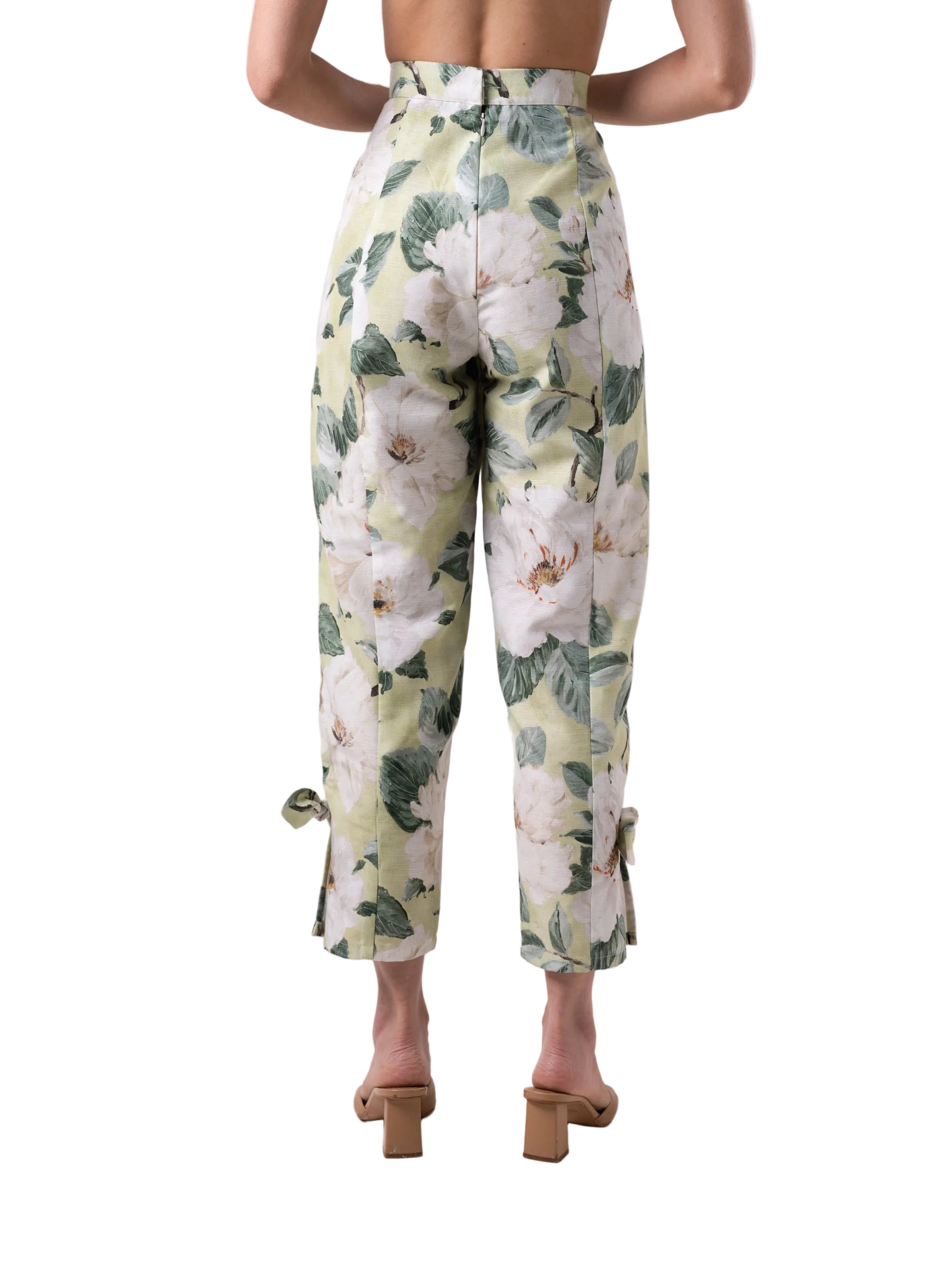 Pants that feature a high waist straight leg silhouette with slit detail at the ankle with knot detail, and back zipper closure.