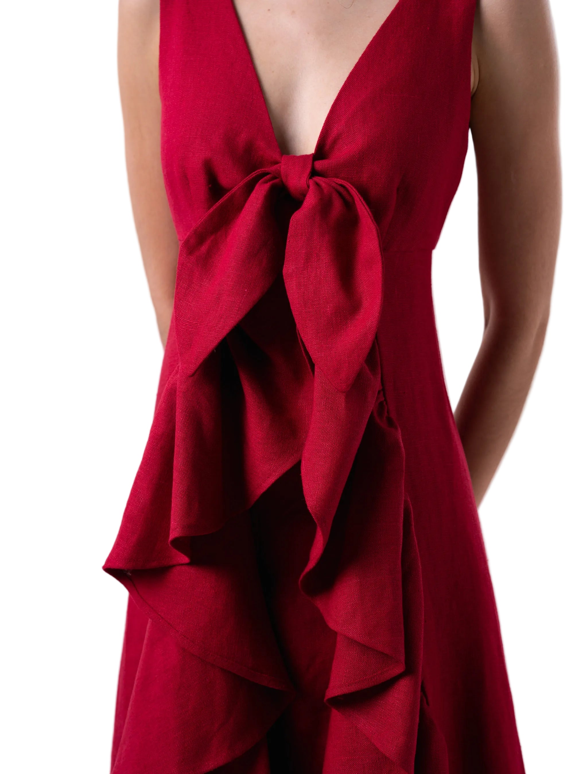 Top that features a sleeveless V neck cut with exaggerated train with ruffle detail.