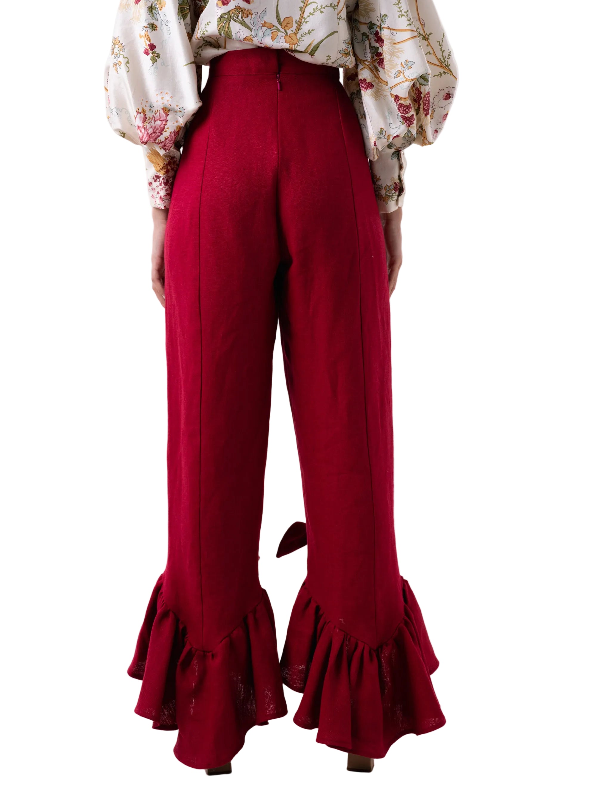 Pant that features a straight leg high waisted silhouette with a cascading ruffle at the ankle with knot detail, and back zipper closure.
