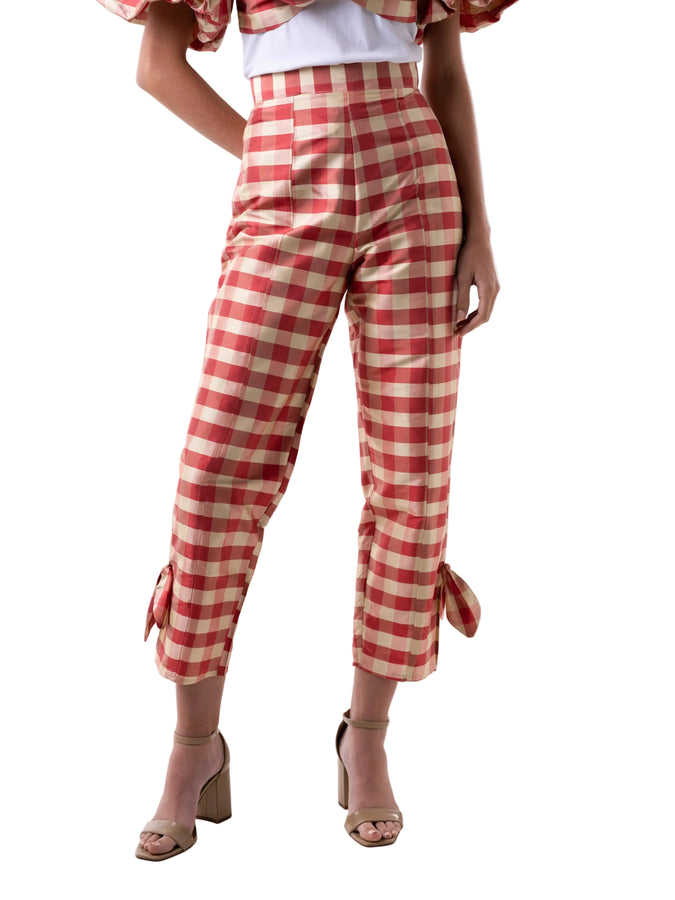 Pants that feature a high waist straight leg silhouette with slit detail at the ankle with knot detail, and back zipper closure.