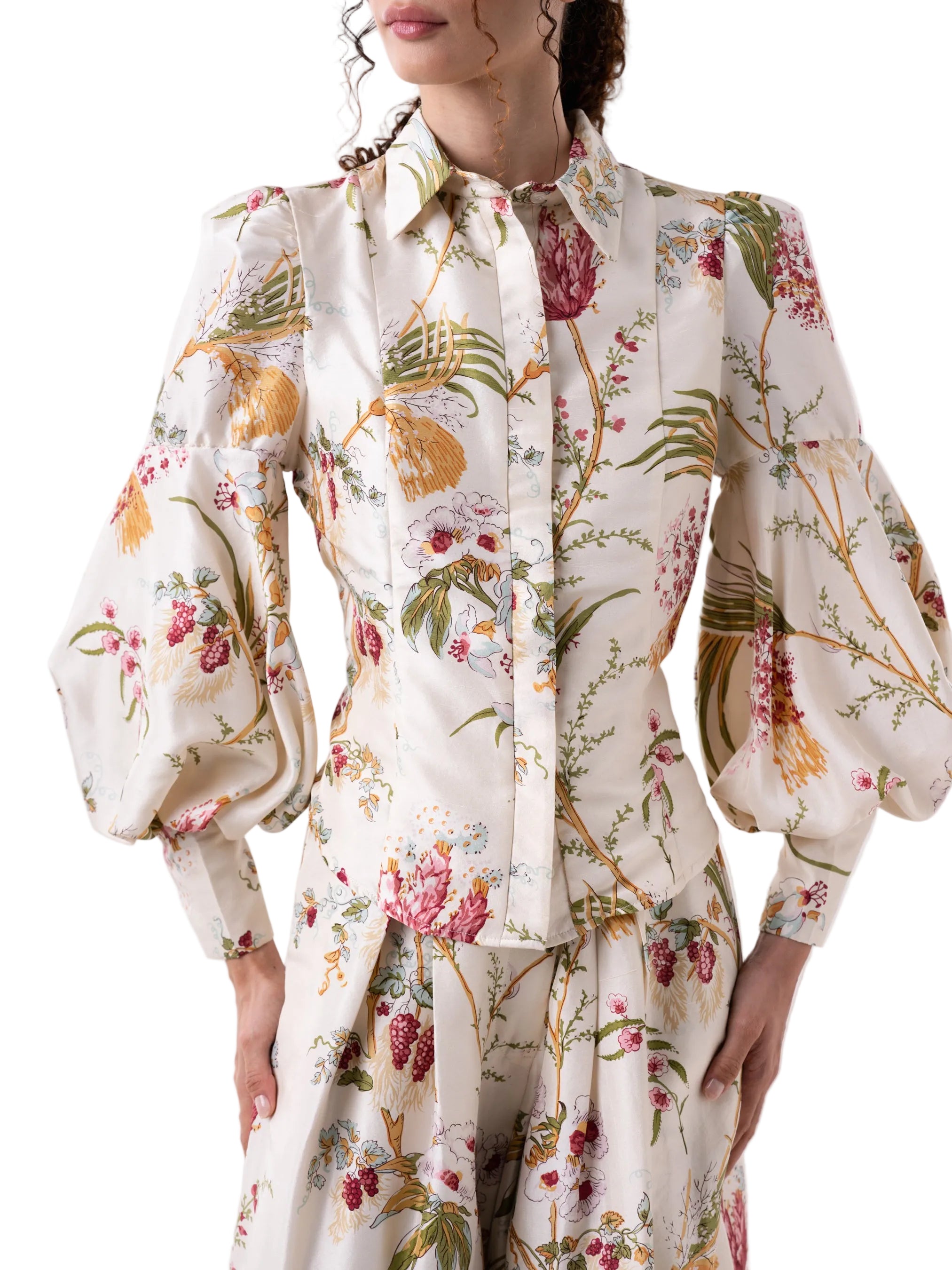 Top that features a long sleeve button down, classic collar top, with hidden front plaquette, accentuated puff sleeves with exaggerated cuff and tier drop shape.