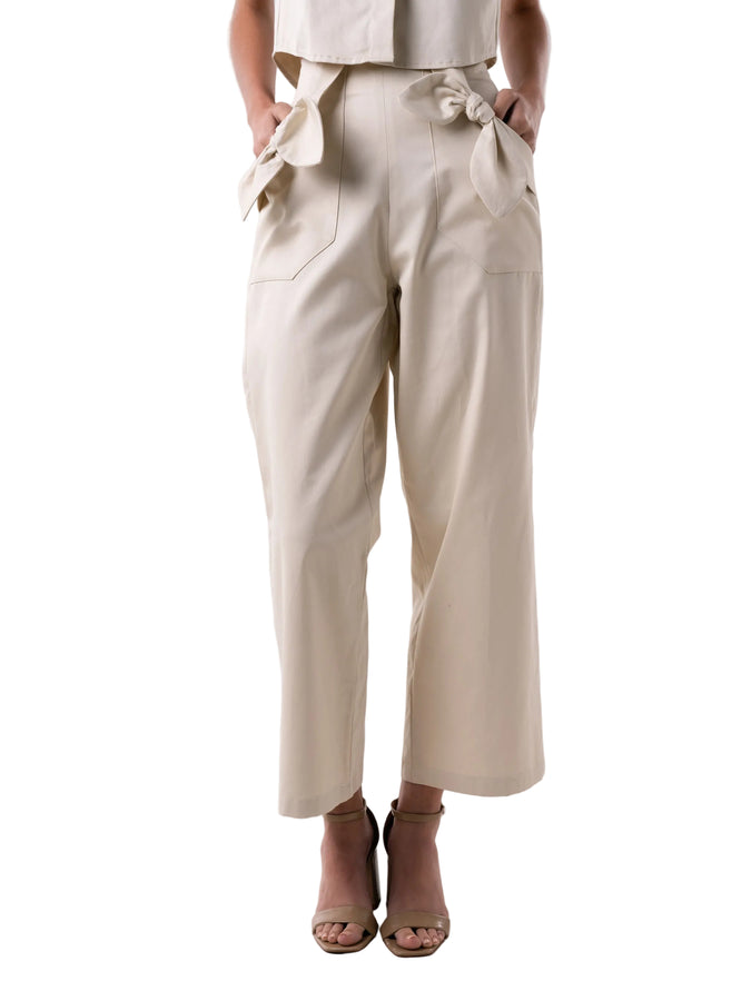 Pant with high waisted relaxed silhouette, elastic back waist band, side zipper closure, and front pockets adorned with knot details.
