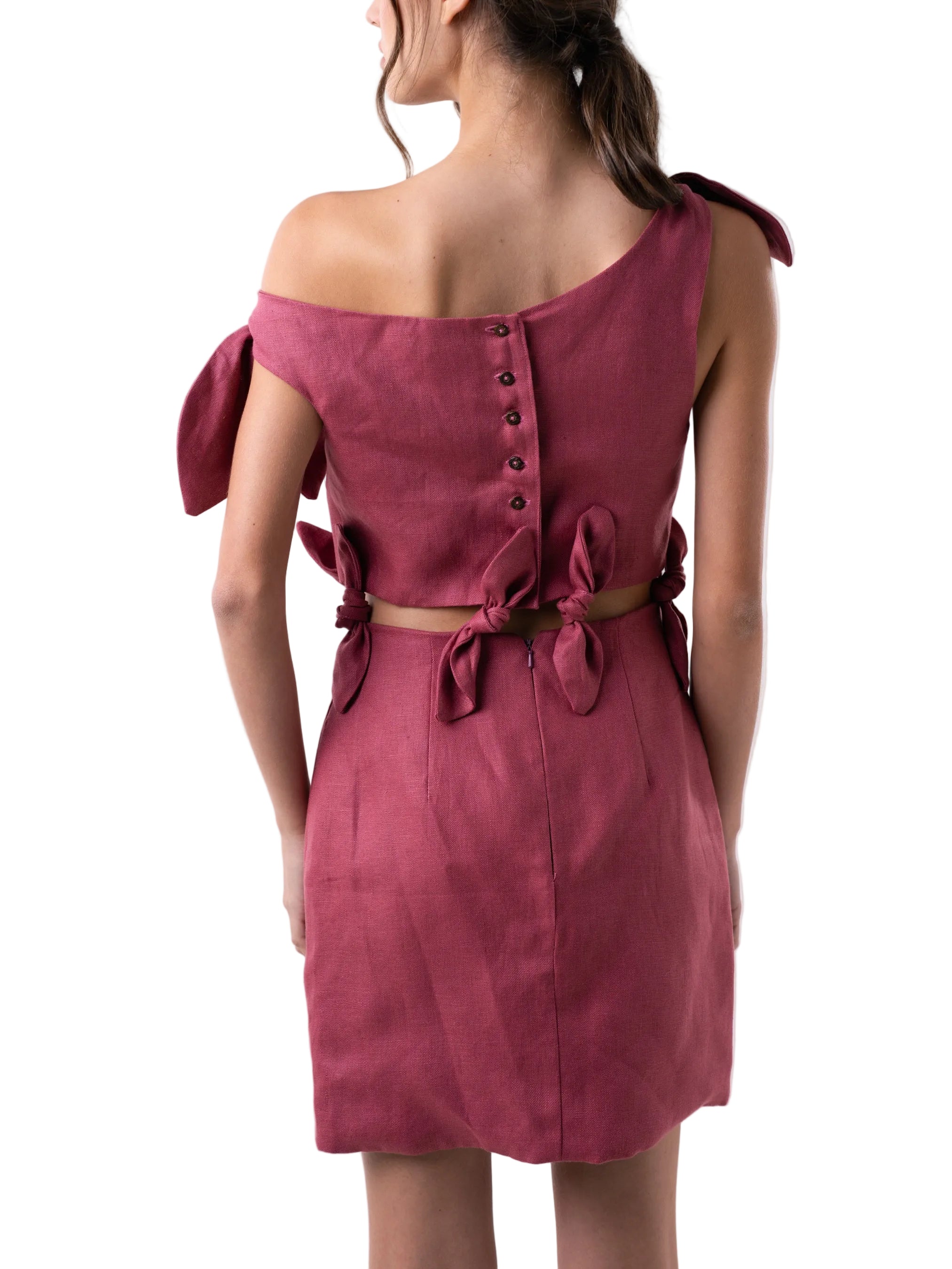 Dress with a loose silhouette, above the knee length, and cut out detail above the waist, adorned with knot details at the waist cut out, and shoulders. 