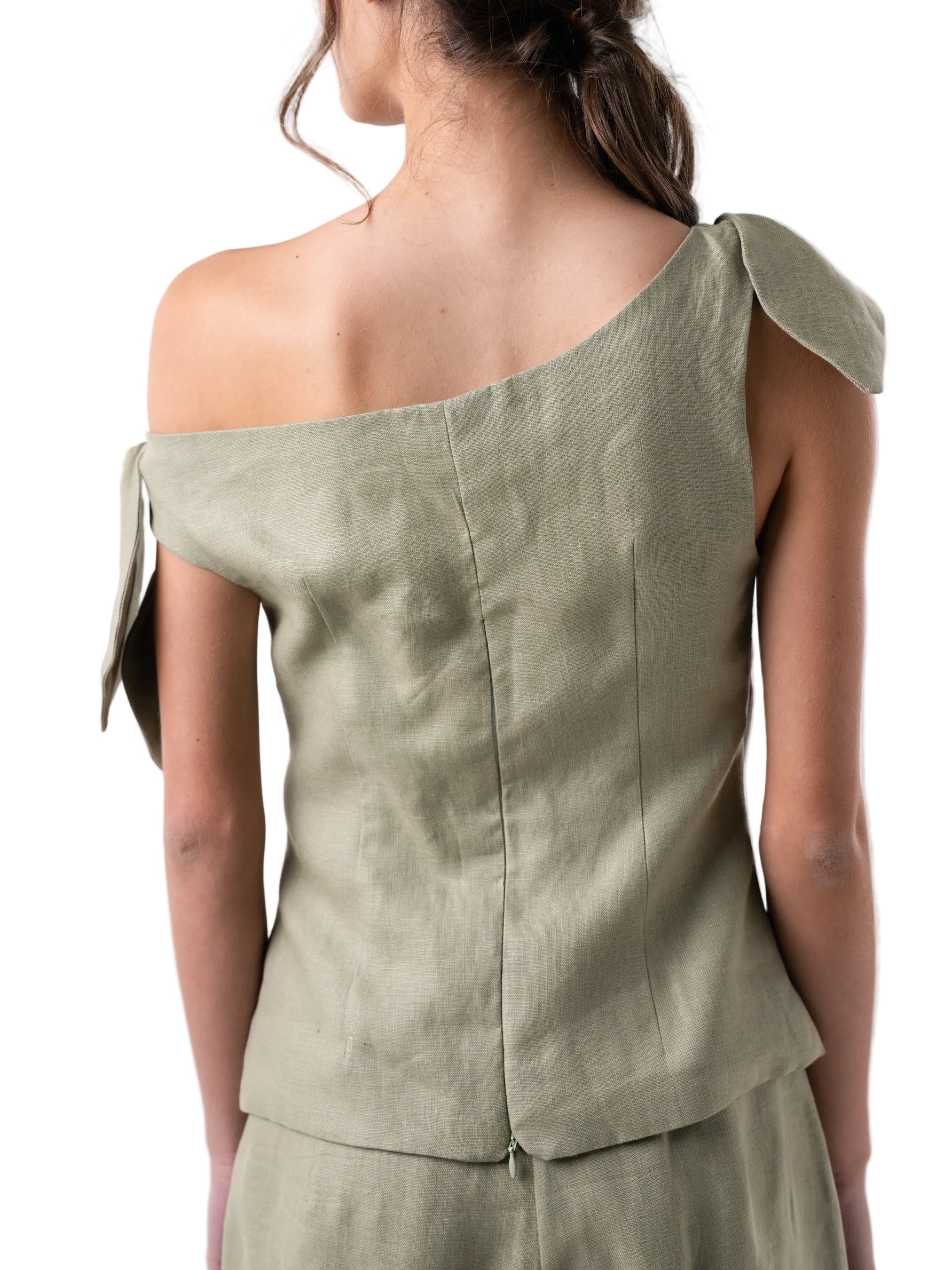 Top features a relaxed drop waist silhouette with single drop shoulder and petal knot detail.