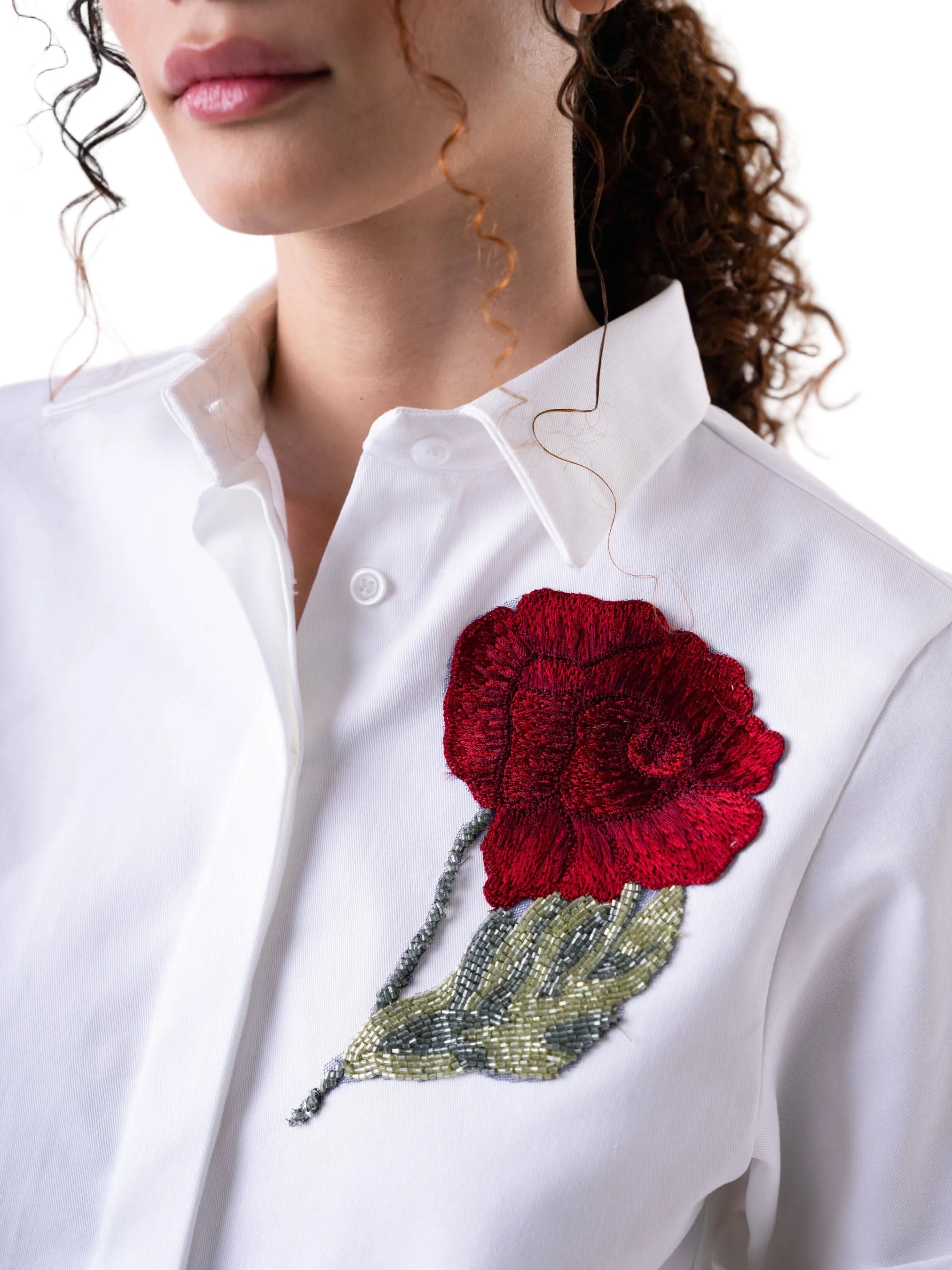 White short sleeve classic button down top, with a cropped silhouette, cuff detail and floral motif embroidery.