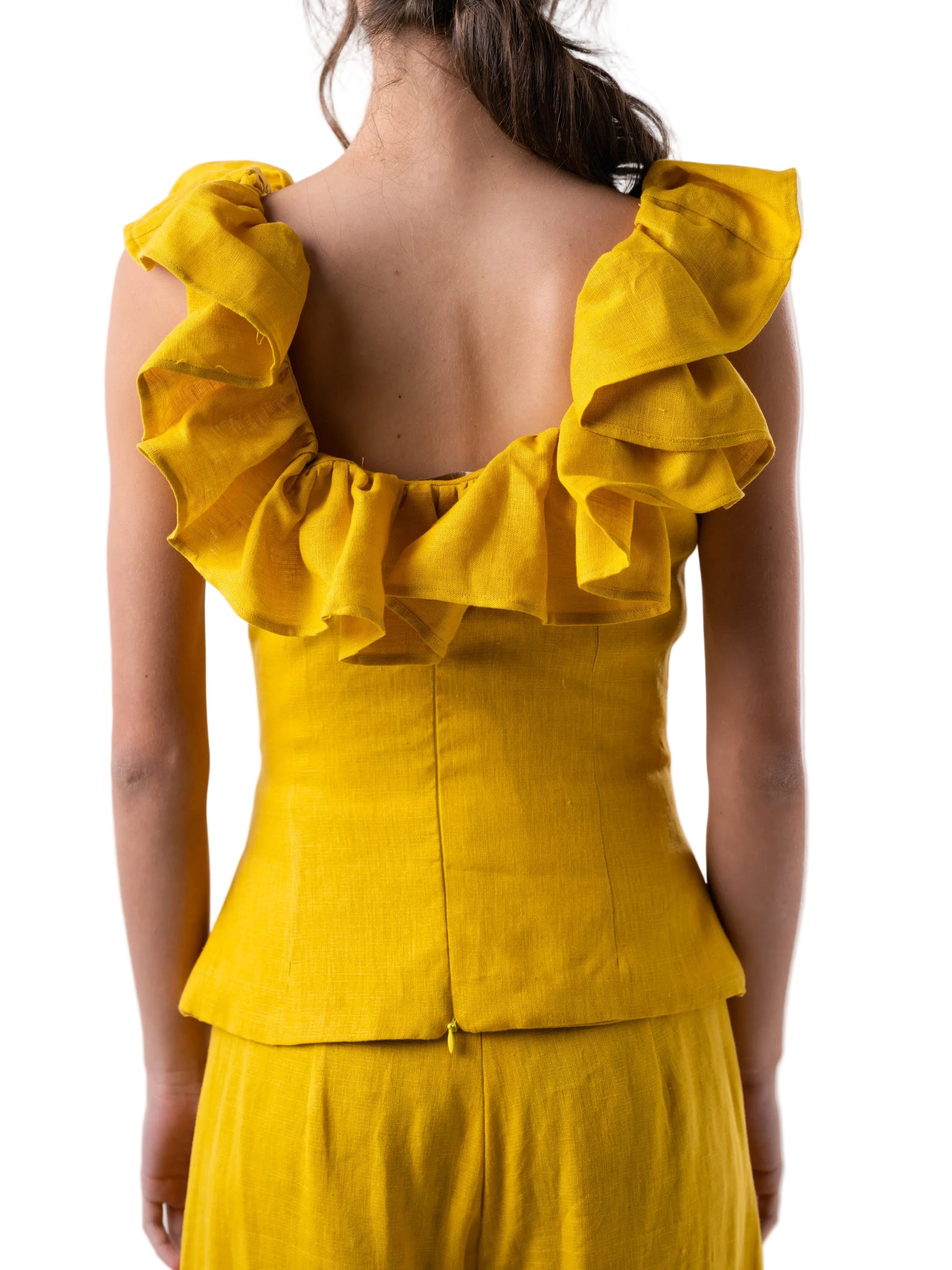 Top that features a sleeve less fitted silhouette with ruffle details around the neckline and back zipper closure.