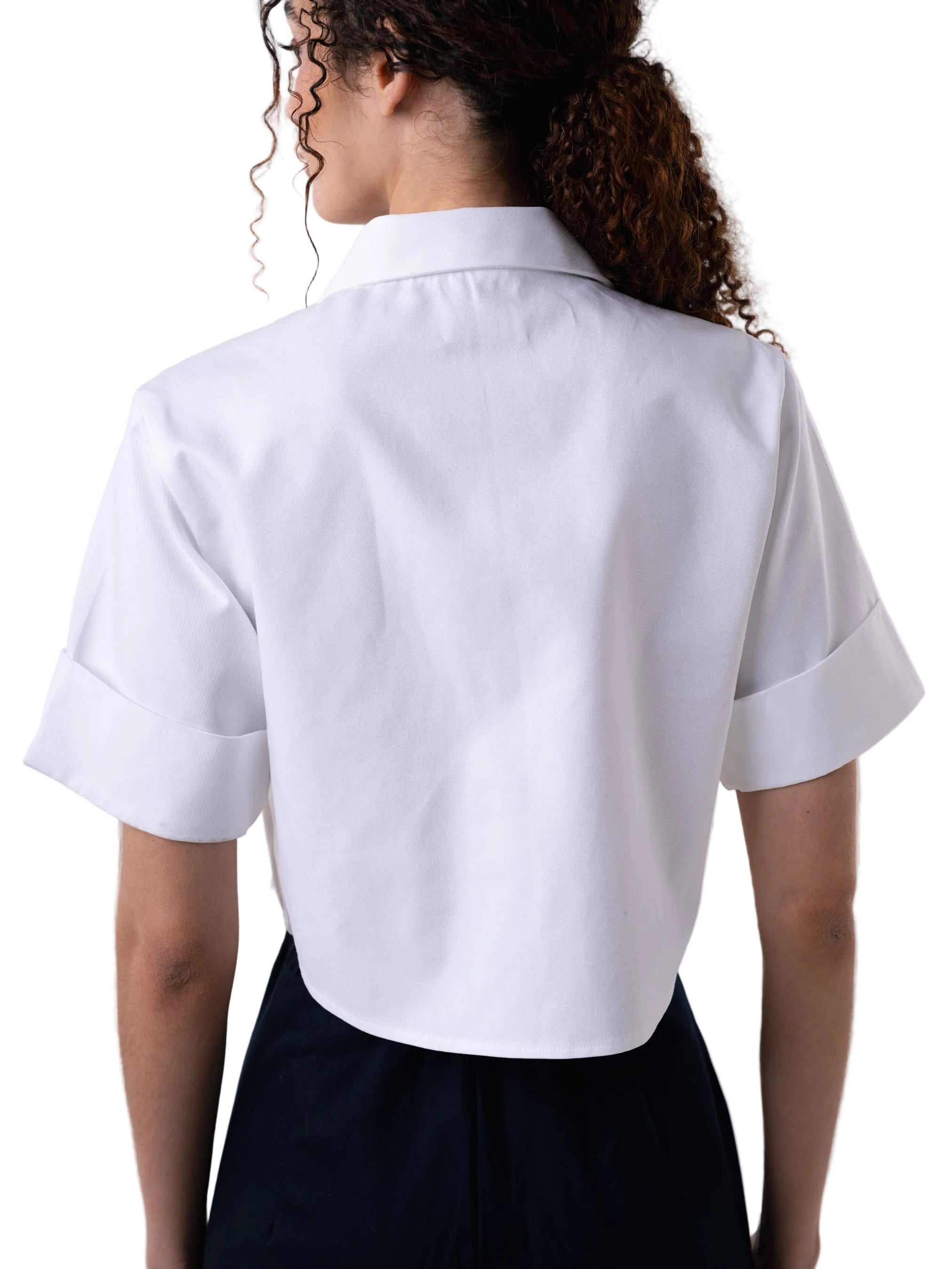 Top that features cropped short sleeve silhouette, classic open collar, sleeve cuff, front button down closure and cargo pockets with petal knot detail.