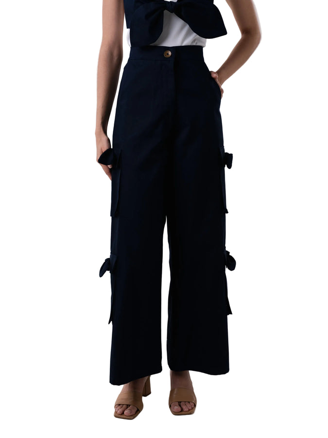 Pant with high waisted cargo style, front zipper, and oversized pockets down the leg with knot details. 